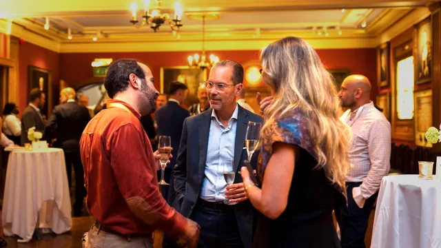 Delegates talking over drinks at an evening reception